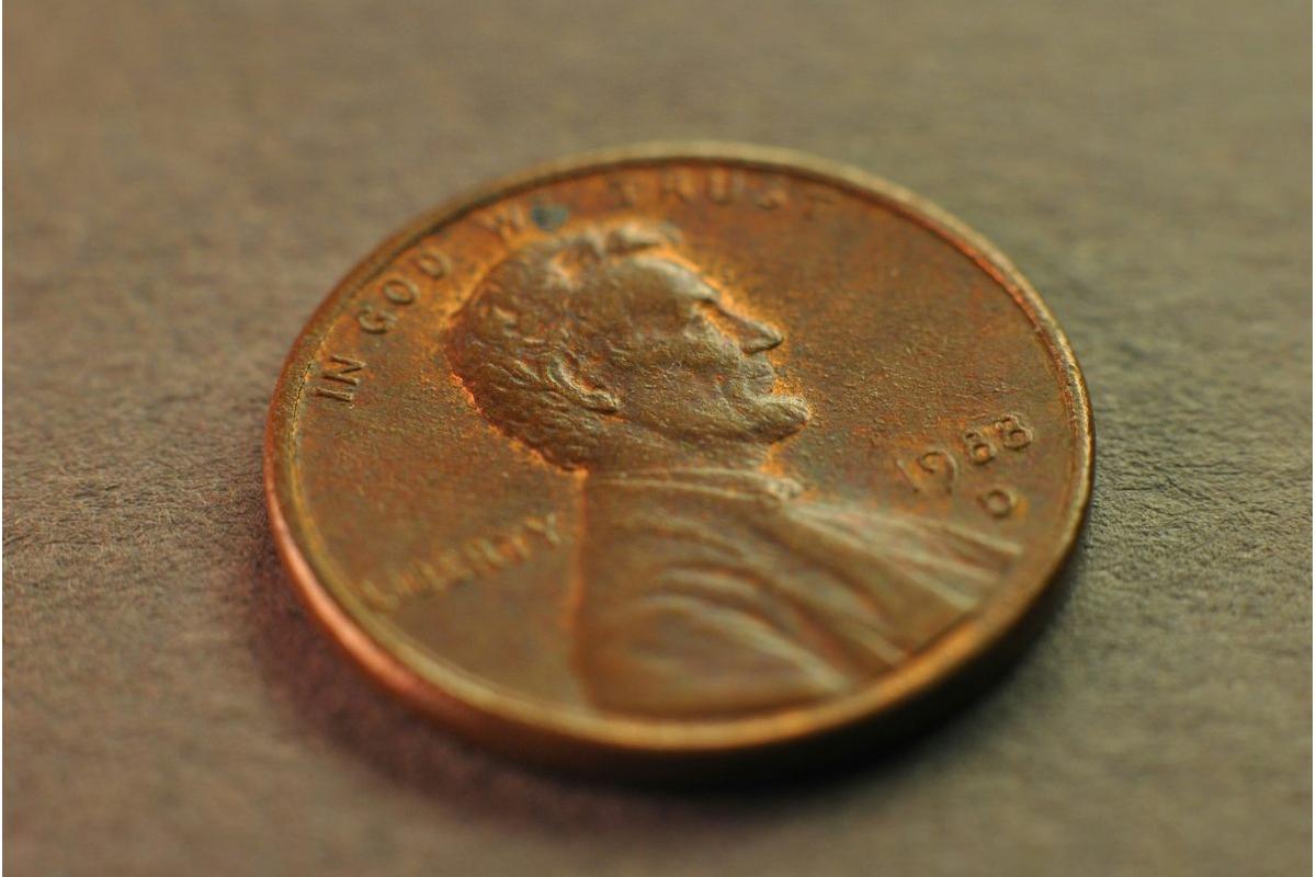 Immagine di una mano che tiene un penny, simbolo dell'addio alla moneta da un centesimo.